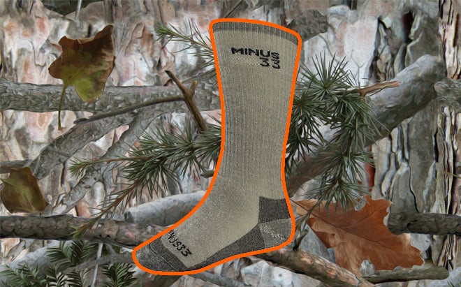 Minus33 Expedition Mountaineering merino wool sock on realistic 3D forest camo background